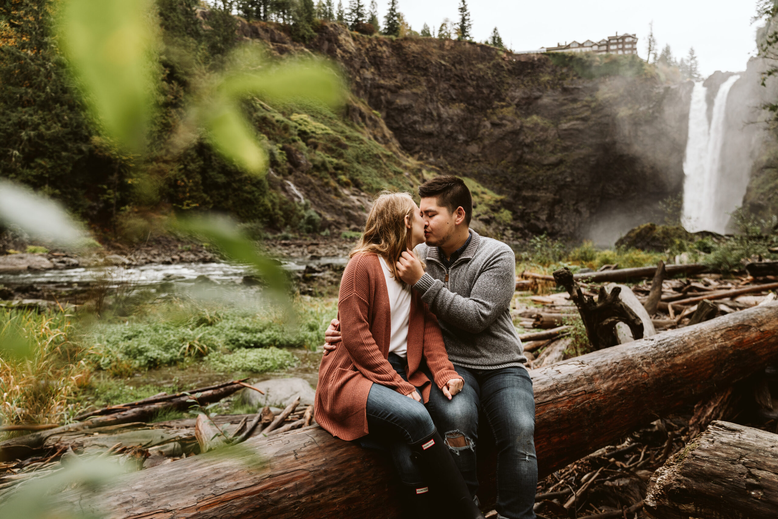 surprise proposal and couple kissing at the bottom of snoqualmie falls
