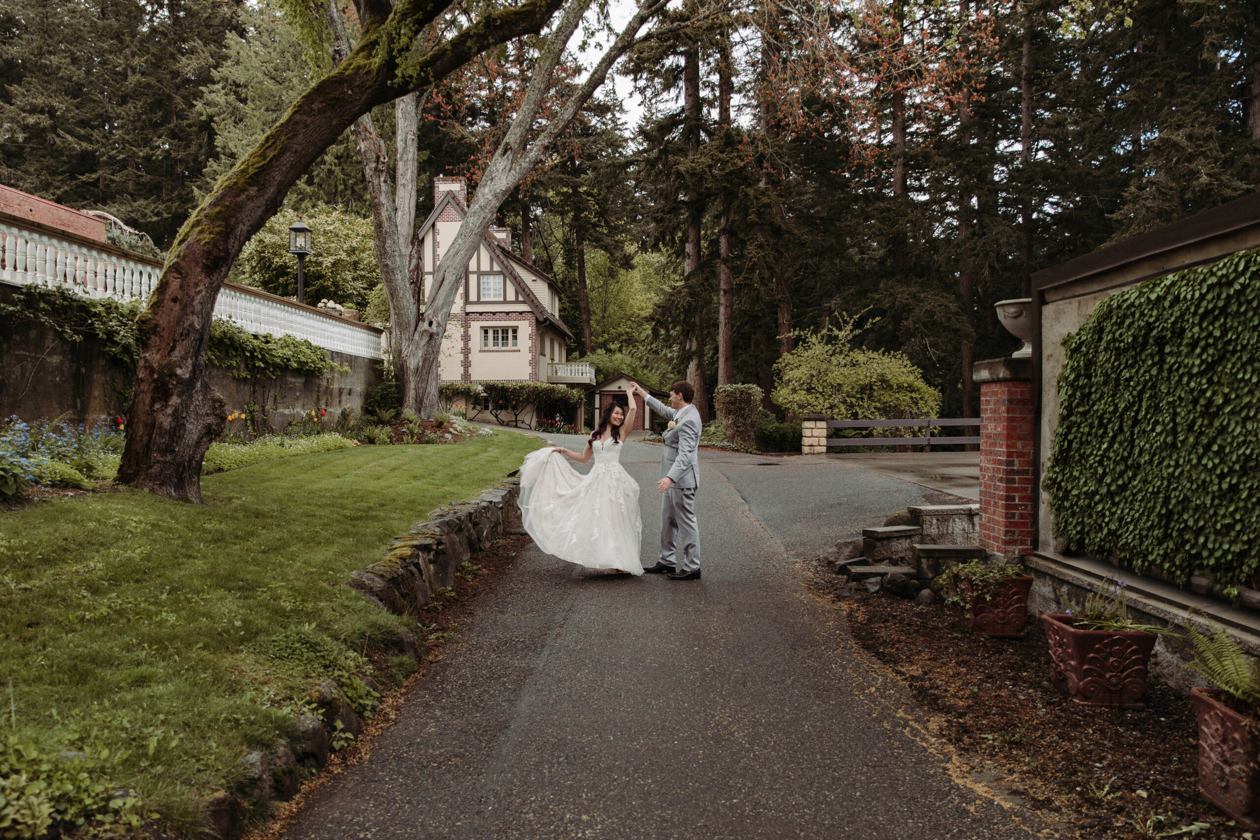 Couple twirling under old oak trees at Lairmont Manor