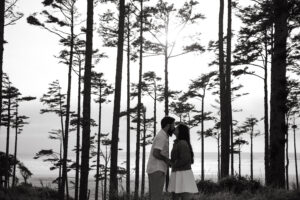 black and white engagement session in pacific beach, kissing in the treeline. 