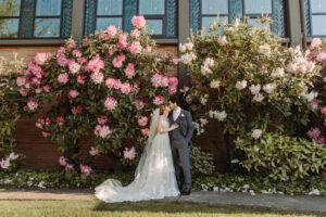 Annileise + Aodhan kissing under the beautiful rhododendrons at St. Monica's Catholic Church in Mercer Island.